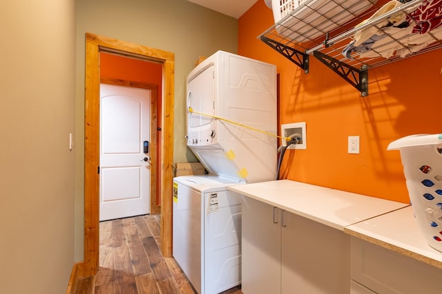 washroom featuring estacked washer and dryer and wood finished floors