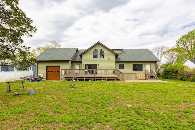 back of house with a shingled roof, a garage, and a wooden deck