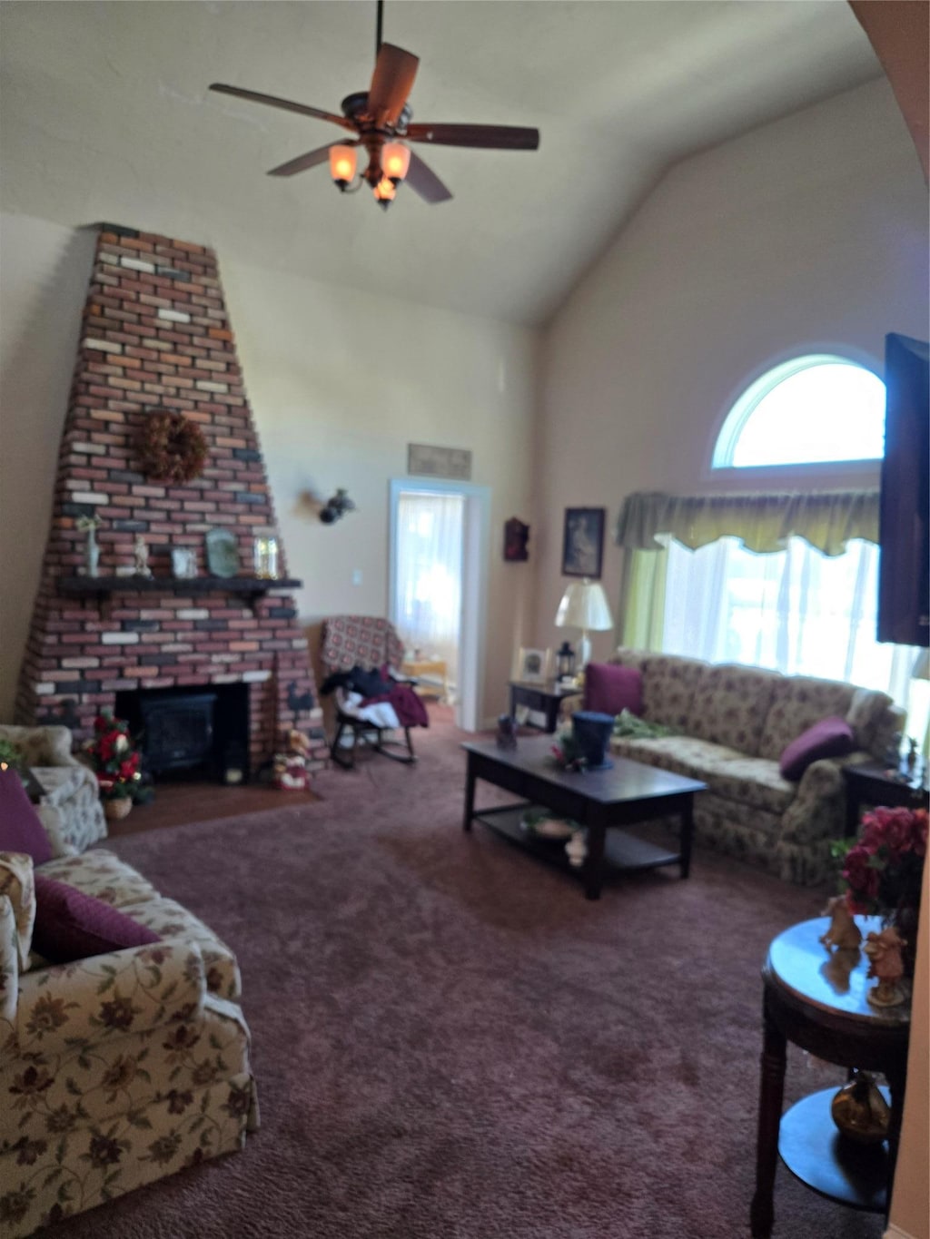 12 Bay Front Dr, Baldwin, NY 11510 - living area with carpet, a ceiling fan, a brick fireplace, and high vaulted ceiling