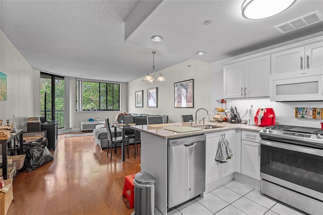 50 E Hartsdale Ave Unit 3S, Hartsdale, NY 10530 - kitchen with appliances with stainless steel finishes, a sink, open floor plan, white cabinets, and recessed lighting