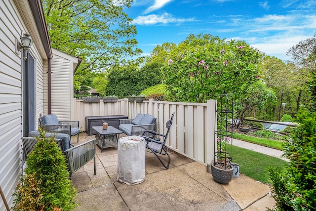 view of patio featuring fence and view of wooded area