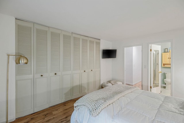 bedroom featuring wood finished floors and ensuite bath