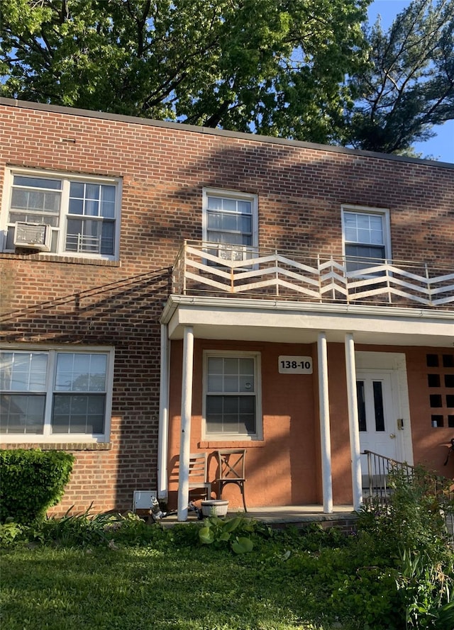 view of front of property with a balcony and brick siding