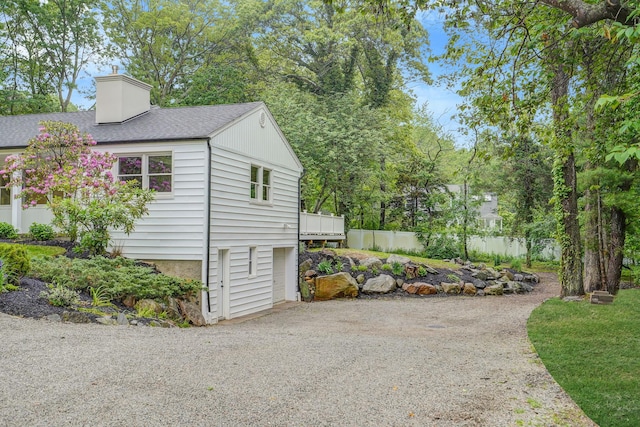3 Thomas Dr, Wading River, NY 11792 - view of side of home featuring a chimney, roof with shingles, and gravel driveway