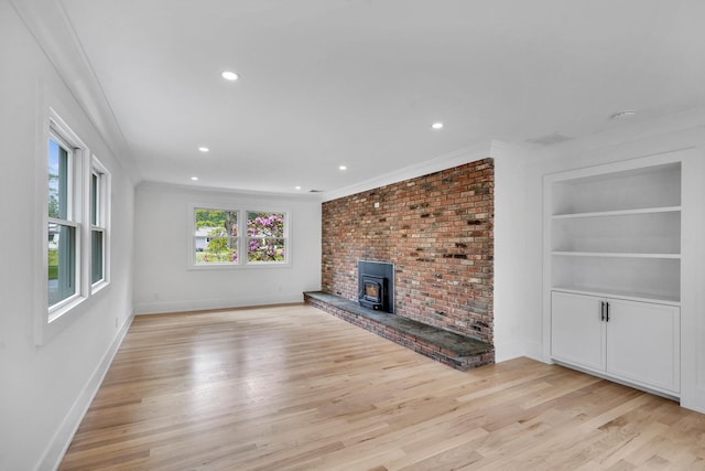 3 Thomas Dr, Wading River, NY 11792 - unfurnished living room featuring light wood-type flooring, baseboards, ornamental molding, recessed lighting, and a wood stove