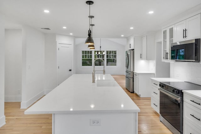 3 Thomas Dr, Wading River, NY 11792 - kitchen featuring appliances with stainless steel finishes, a sink, a kitchen island with sink, white cabinetry, and light wood-type flooring