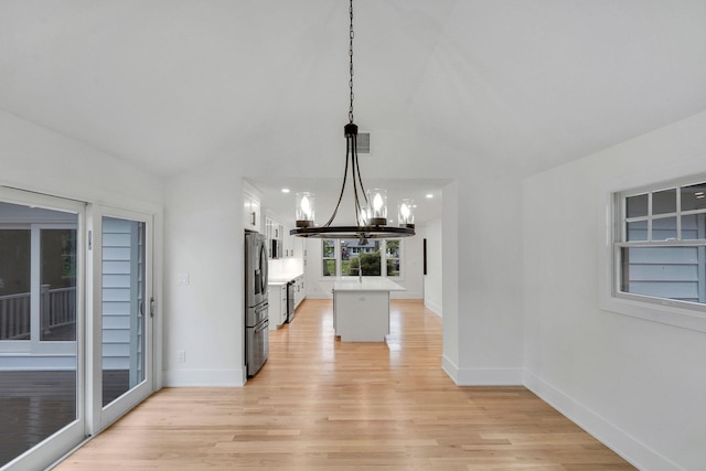 3 Thomas Dr, Wading River, NY 11792 - kitchen featuring stainless steel refrigerator with ice dispenser, a chandelier, light wood-style floors, white cabinetry, and baseboards