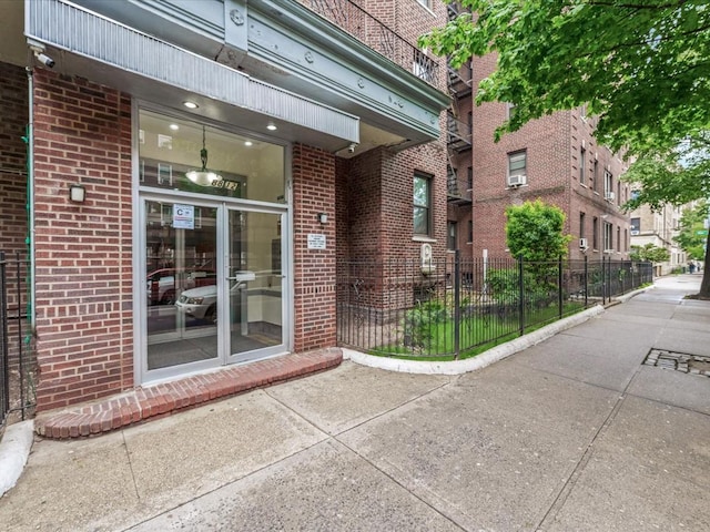 property entrance with brick siding and fence