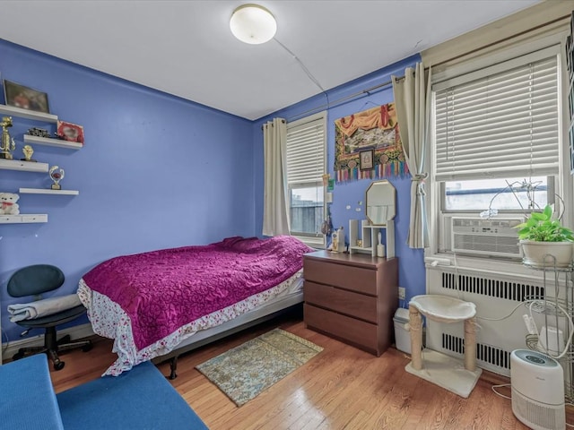 bedroom with radiator and wood finished floors