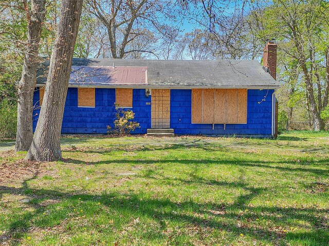 144 Union Ave, Patchogue, NY 11772 - view of front of home featuring a chimney, a front yard, and roof with shingles