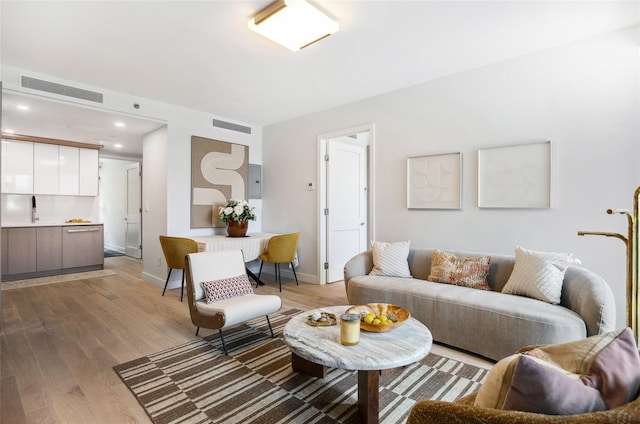 living area with light wood-type flooring, baseboards, and recessed lighting