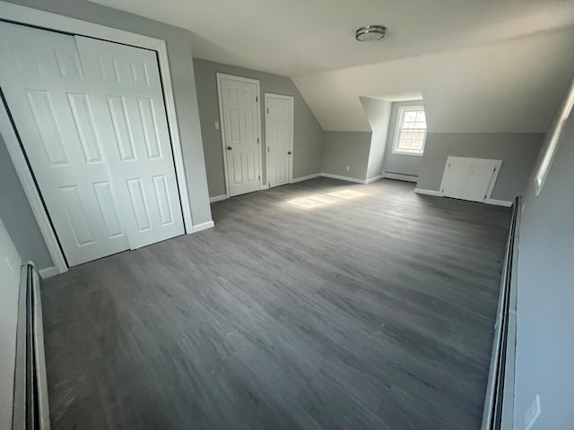 57 Doud St, Farmingdale, NY 11735 - additional living space featuring baseboard heating, baseboards, vaulted ceiling, and dark wood-style floors