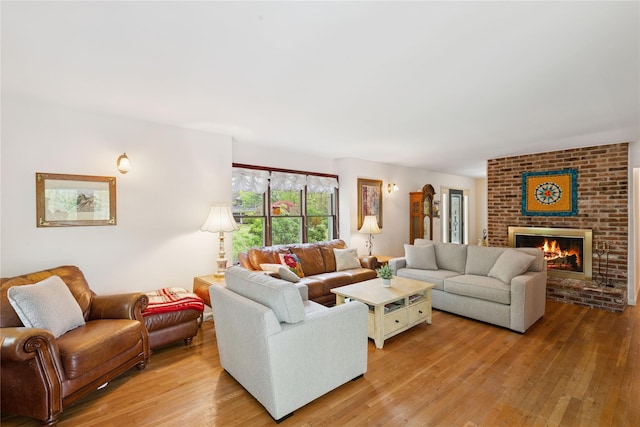 6 Carriage Path, Manorville, NY 11949 - living room featuring light wood-style flooring and a brick fireplace