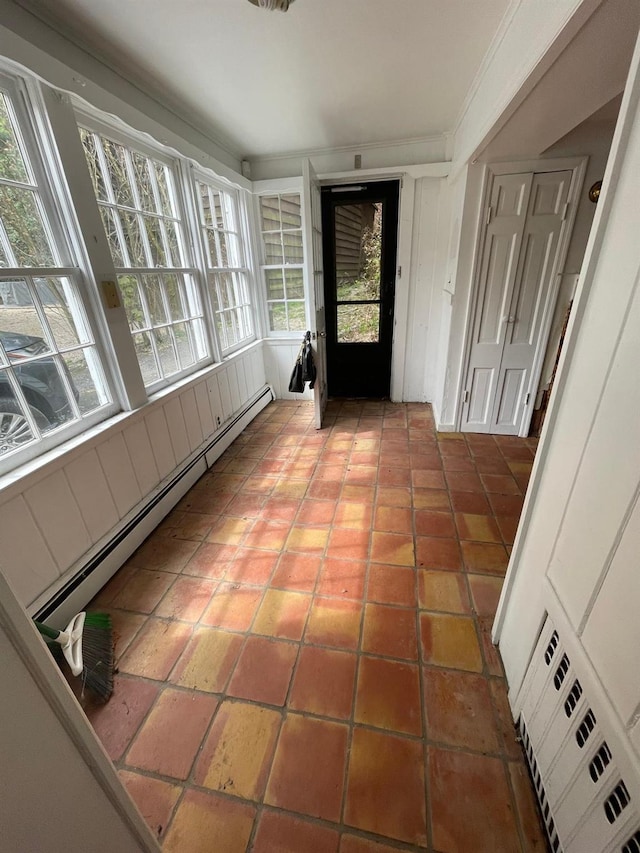 unfurnished sunroom featuring baseboard heating, healthy amount of natural light, and tile patterned flooring