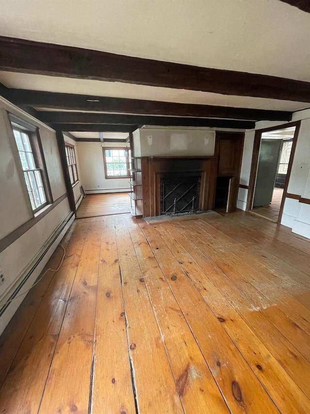 unfurnished living room featuring hardwood / wood-style flooring, beam ceiling, a fireplace, and baseboard heating