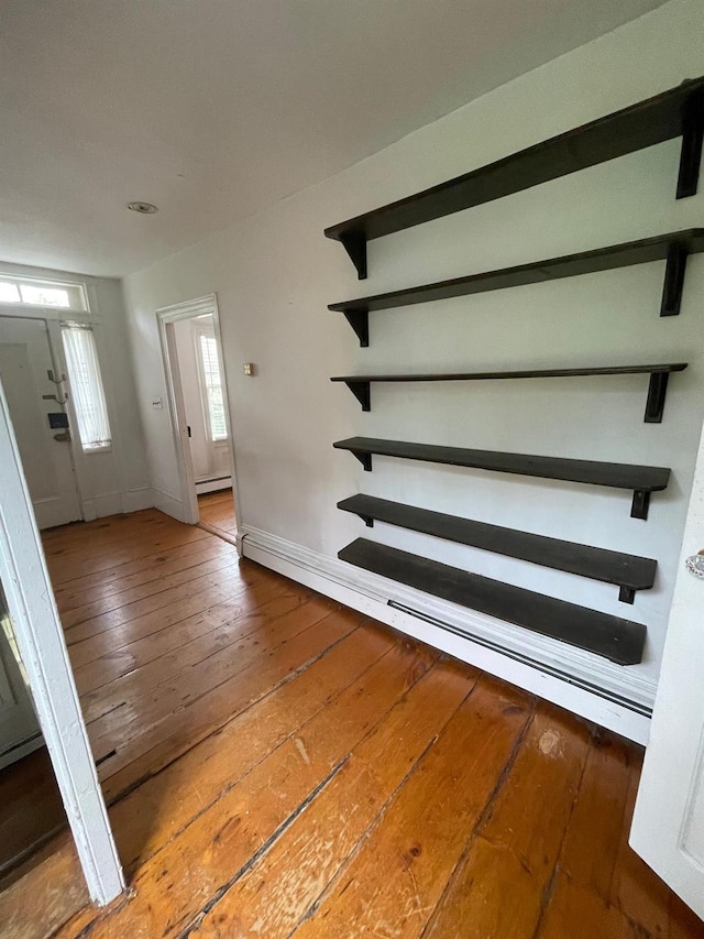 foyer featuring wood-type flooring, baseboards, and a baseboard heating unit