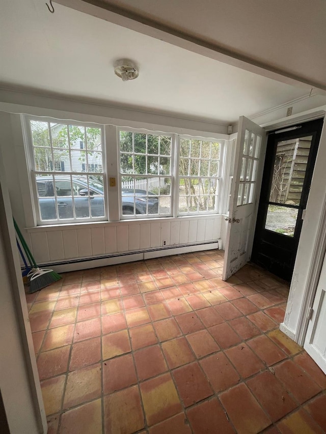 unfurnished sunroom featuring a baseboard heating unit and plenty of natural light