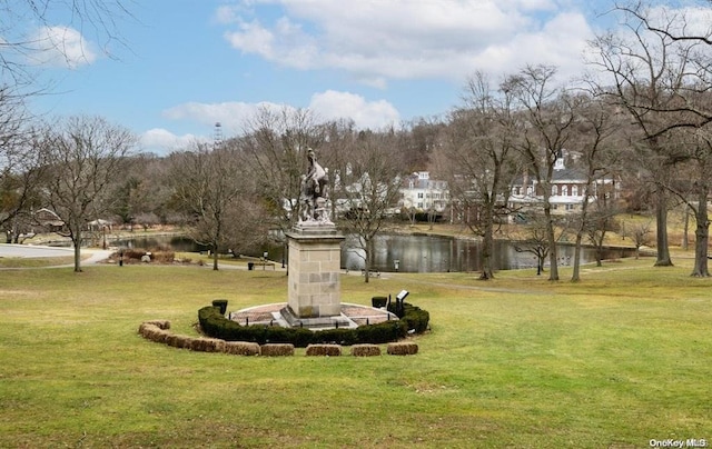 surrounding community with a lawn and a water view