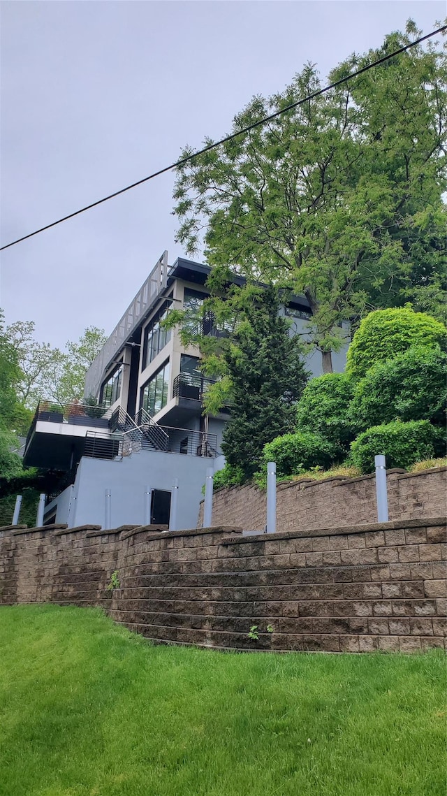view of property exterior featuring a balcony and a yard