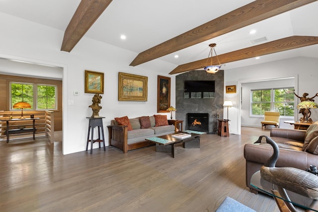 living area with recessed lighting, a premium fireplace, wood finished floors, beam ceiling, and baseboards