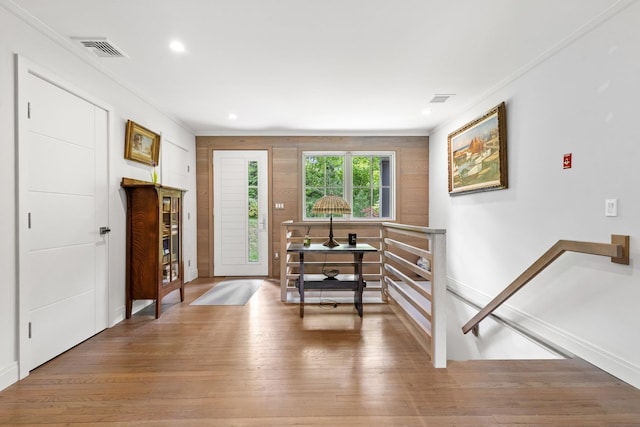 entryway with crown molding, light wood-type flooring, baseboards, and recessed lighting