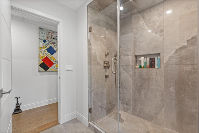 bathroom featuring a shower stall, baseboards, and wood finished floors
