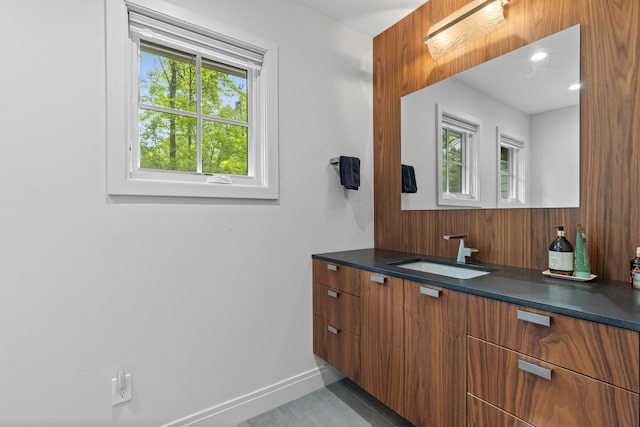 bathroom featuring vanity, baseboards, and wood walls