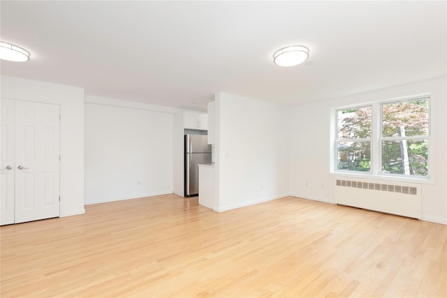 1 Hawley Ter Unit 5E, Yonkers, NY 10701 - spare room featuring radiator heating unit, light wood finished floors, and baseboards