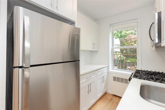 1 Hawley Ter Unit 5E, Yonkers, NY 10701 - kitchen with appliances with stainless steel finishes, radiator heating unit, light countertops, and white cabinets