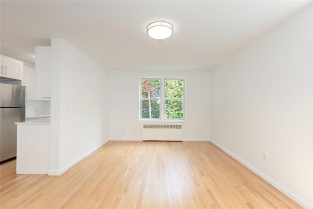 1 Hawley Ter Unit 5E, Yonkers, NY 10701 - spare room featuring radiator heating unit, light wood-type flooring, and baseboards