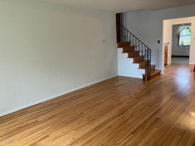 16615 67th Ave, Fresh Meadows, NY 11365 - unfurnished living room with wood finished floors, stairs, and baseboards