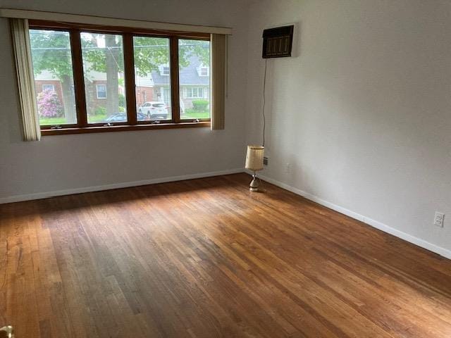 16615 67th Ave, Fresh Meadows, NY 11365 - spare room with wood finished floors, baseboards, and a wall mounted AC