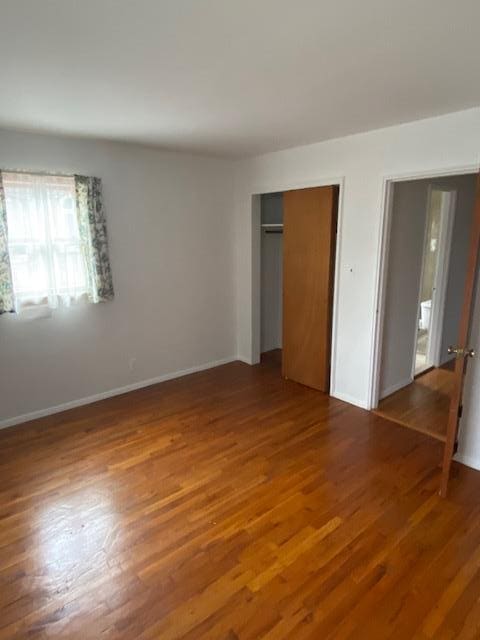 16615 67th Ave, Fresh Meadows, NY 11365 - unfurnished bedroom featuring wood finished floors, a closet, and baseboards