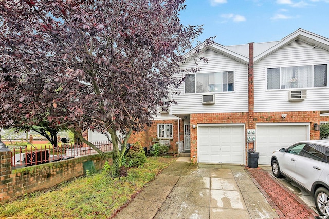 303 Howe Ave, Bronx, NY 10473 - view of front of property featuring driveway, a garage, brick siding, and fence