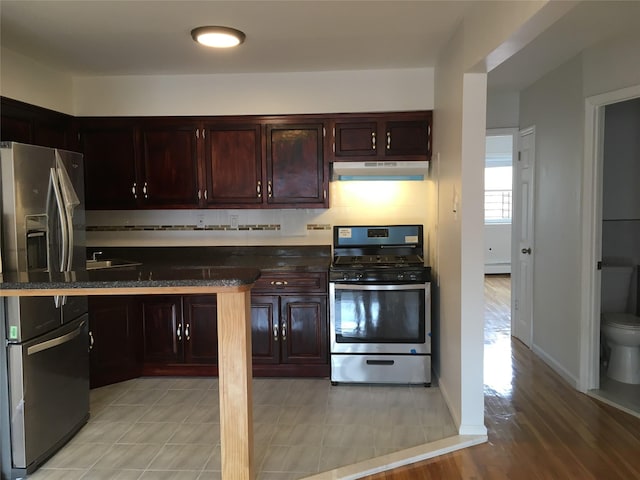3314 Wickham Ave, Bronx, NY 10469 - kitchen featuring stainless steel appliances, under cabinet range hood, dark brown cabinetry, and a sink
