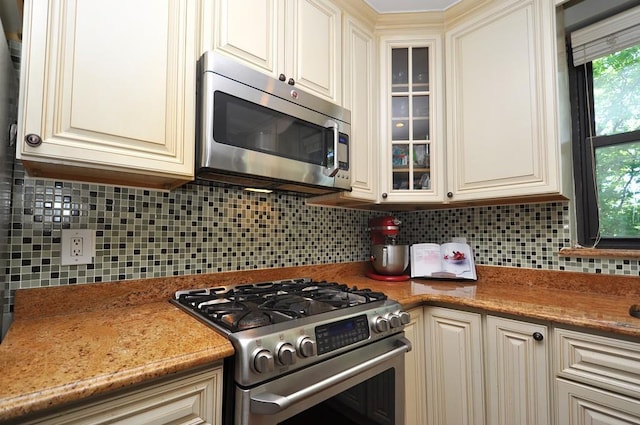 67 Rockledge Rd Unit 2A, Hartsdale, NY 10530 - kitchen with stainless steel appliances, glass insert cabinets, backsplash, and cream cabinetry