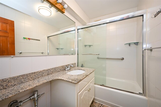bathroom featuring shower / bath combination with glass door and vanity