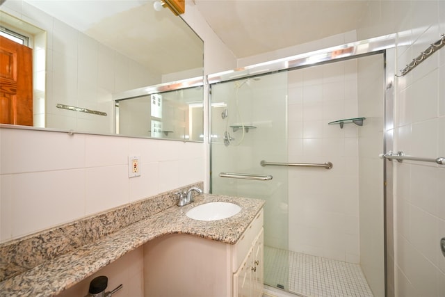 full bath with a stall shower and vanity