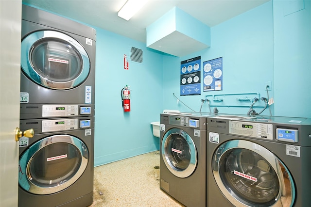 shared laundry room featuring washing machine and clothes dryer, estacked washer and dryer, and baseboards