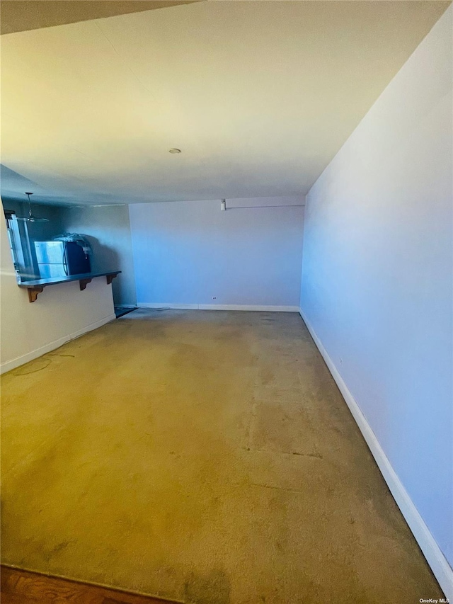 102-21 63rd Rd Unit 47A, Forest Hills, NY 11375 - unfurnished living room featuring baseboards and carpet flooring