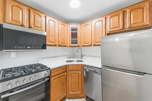9 Sierra Ct Unit 0, Coram, NY 11727 - kitchen with appliances with stainless steel finishes, a sink, glass insert cabinets, and light stone countertops