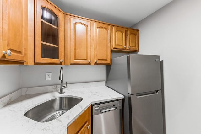 9 Sierra Ct Unit 0, Coram, NY 11727 - kitchen featuring appliances with stainless steel finishes, a sink, glass insert cabinets, light stone counters, and brown cabinetry