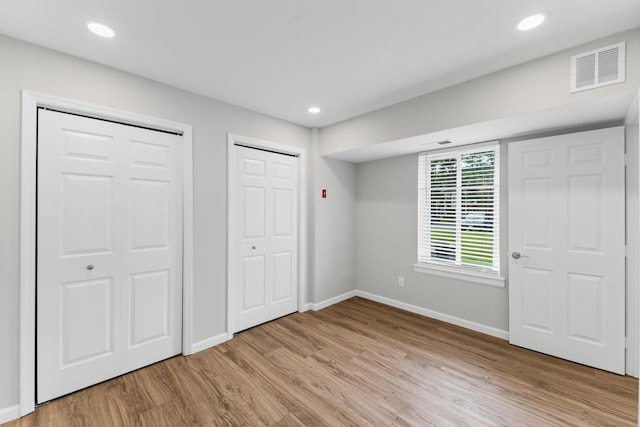 9 Sierra Ct Unit 0, Coram, NY 11727 - unfurnished bedroom with two closets, light wood-style floors, baseboards, and recessed lighting