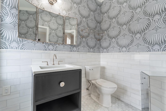 89-10 35th Ave Unit F2L, Jackson Heights, NY 11372 - bathroom featuring wallpapered walls, wainscoting, toilet, vanity, and tile walls