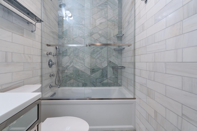 89-10 35th Ave Unit F2L, Jackson Heights, NY 11372 - bathroom featuring bath / shower combo with glass door, tile walls, vanity, and toilet