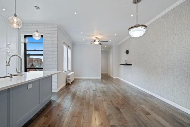 89-10 35th Ave Unit F2L, Jackson Heights, NY 11372 - unfurnished living room featuring radiator heating unit, a sink, baseboards, dark wood finished floors, and ornamental molding