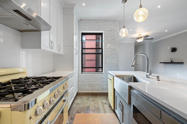89-10 35th Ave Unit F2L, Jackson Heights, NY 11372 - kitchen with stainless steel appliances, wall chimney exhaust hood, brick wall, hardwood / wood-style flooring, and crown molding