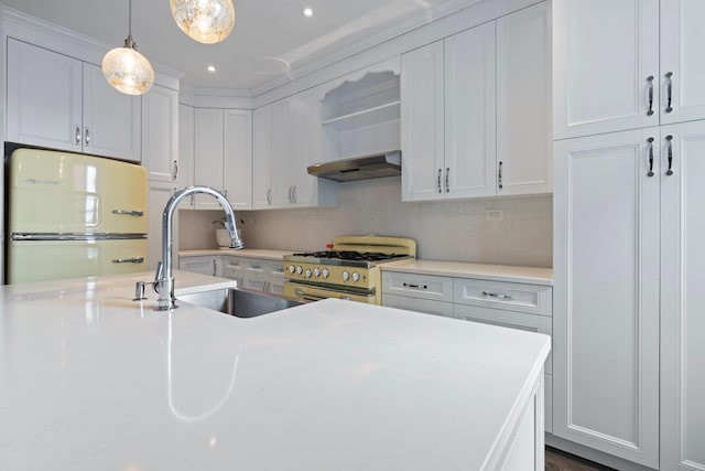 89-10 35th Ave Unit F2L, Jackson Heights, NY 11372 - kitchen with white fridge, stainless steel range with gas stovetop, under cabinet range hood, white cabinets, and recessed lighting