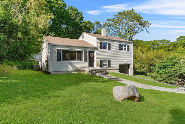 10 Ridge Rd, Cortlandt Manor, NY 10567 - view of front of home with cooling unit, a chimney, an attached garage, a front yard, and a shingled roof
