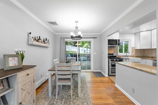 10 Ridge Rd, Cortlandt Manor, NY 10567 - dining room with baseboard heating, a chandelier, plenty of natural light, light wood finished floors, and ornamental molding